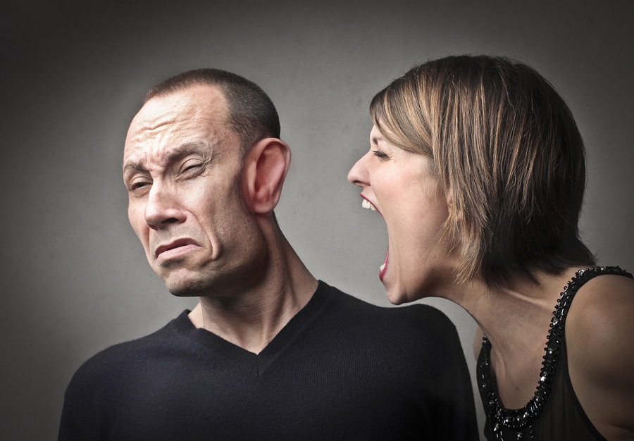 Angry woman screaming against her husband with his face deformed